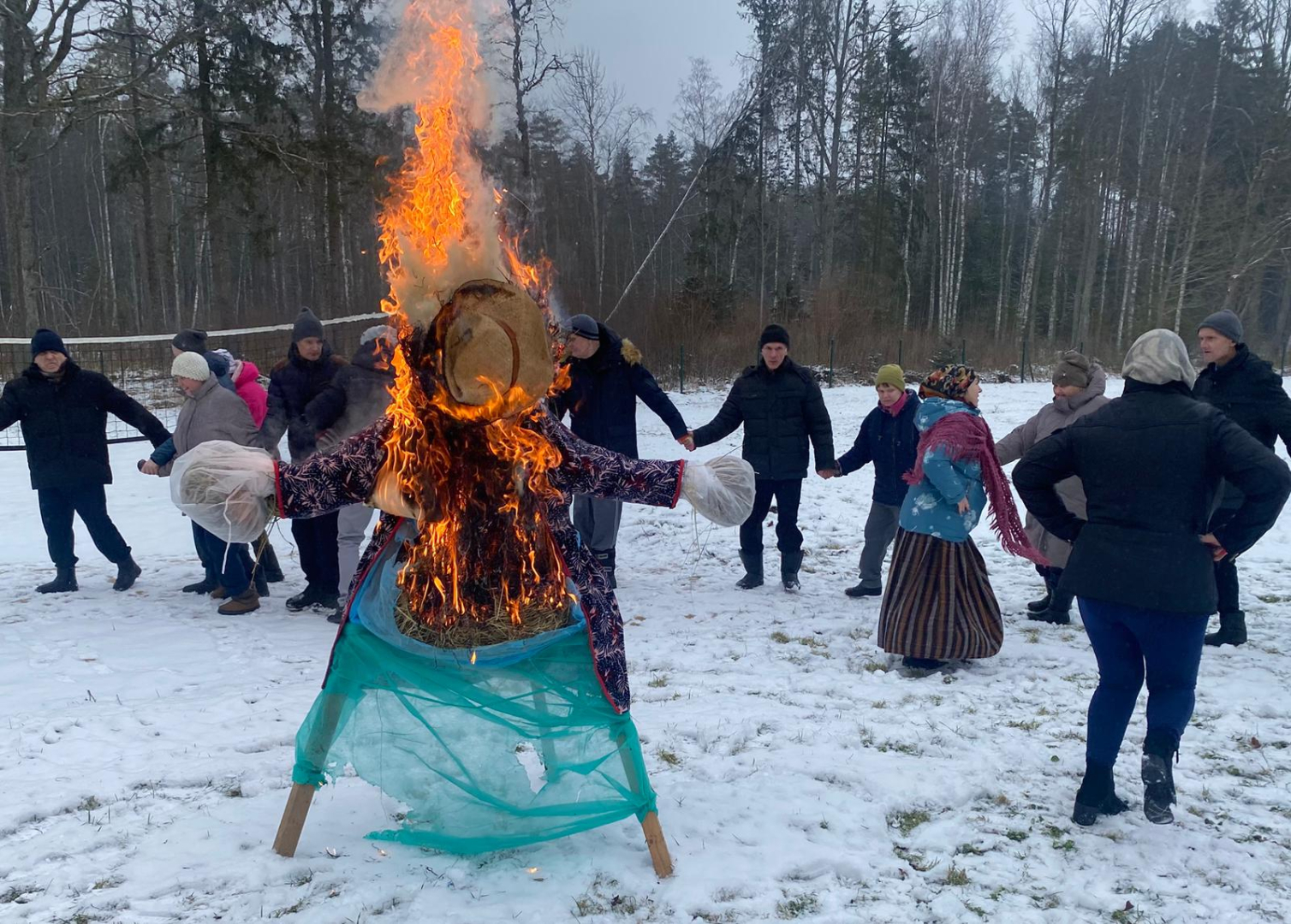 Cilvēki rotaļās ap ugunskuru