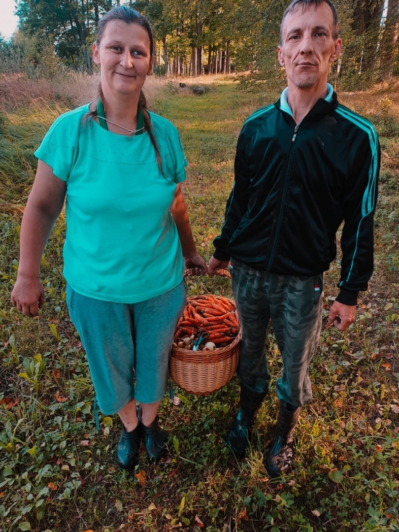 Sieviete un vīrietis tur grozu ar dārzeņiem