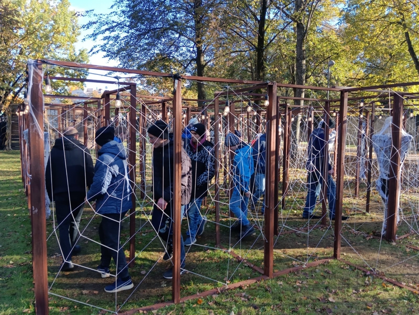 Cilvēku grupa zirnekļu tīklu takā