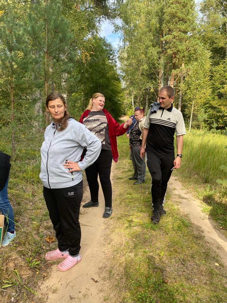 Cilvēku grupa iet pa lauku ceļu